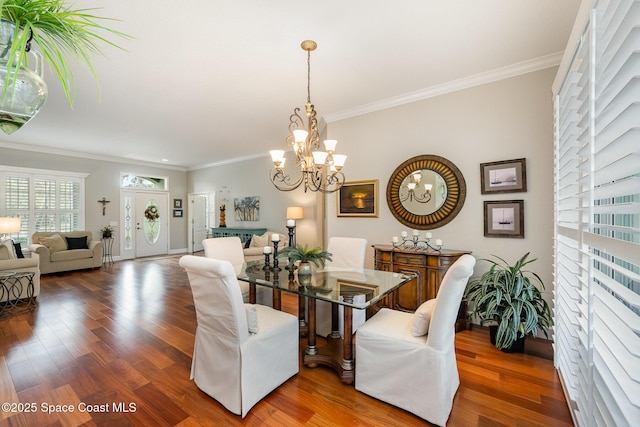 dining area featuring dark wood-type flooring, crown molding, and a chandelier