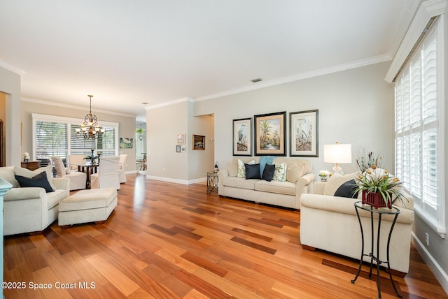 living room with ornamental molding, hardwood / wood-style flooring, and a notable chandelier