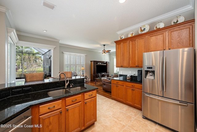 kitchen featuring sink, appliances with stainless steel finishes, ornamental molding, and dark stone countertops