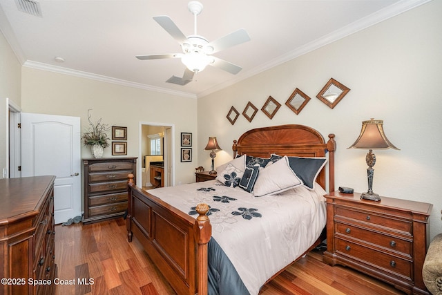 bedroom featuring ceiling fan, wood-type flooring, and crown molding