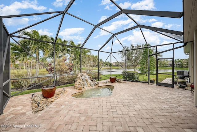 view of patio with a lanai and a water view