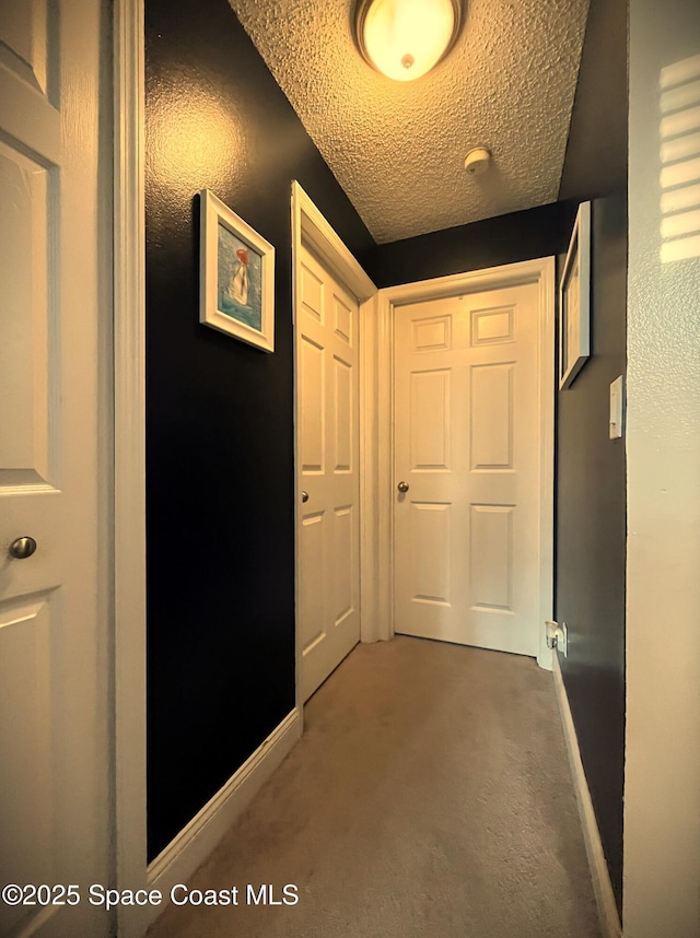 corridor featuring carpet floors and a textured ceiling