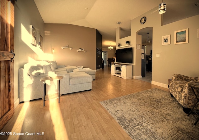 living room with vaulted ceiling and light wood-type flooring