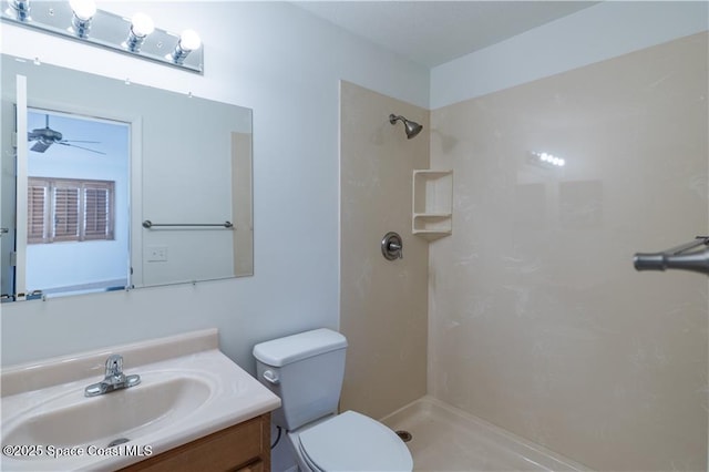 bathroom featuring a shower, toilet, vanity, and ceiling fan