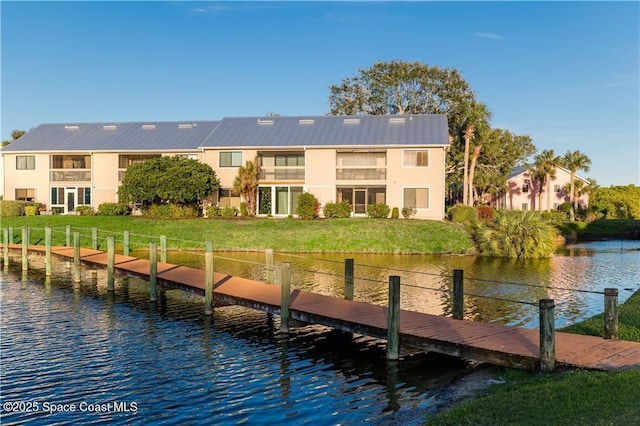 dock area with a lawn and a water view