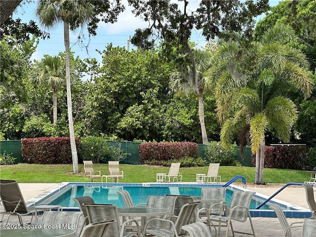 view of swimming pool featuring a yard