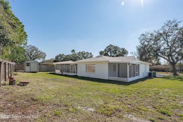 rear view of house featuring a lawn, a shed, a sunroom, and central air condition unit