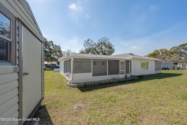 back of property featuring a lawn and a sunroom