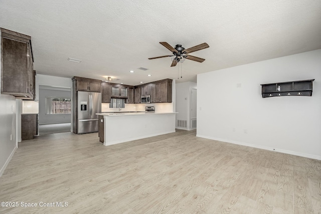 kitchen with ceiling fan, appliances with stainless steel finishes, dark brown cabinets, and light hardwood / wood-style flooring