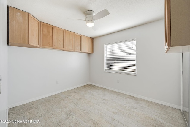 spare room featuring light hardwood / wood-style floors and ceiling fan