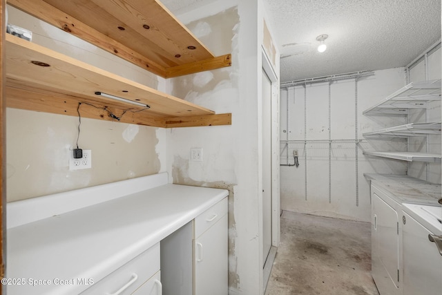 washroom featuring a textured ceiling and independent washer and dryer