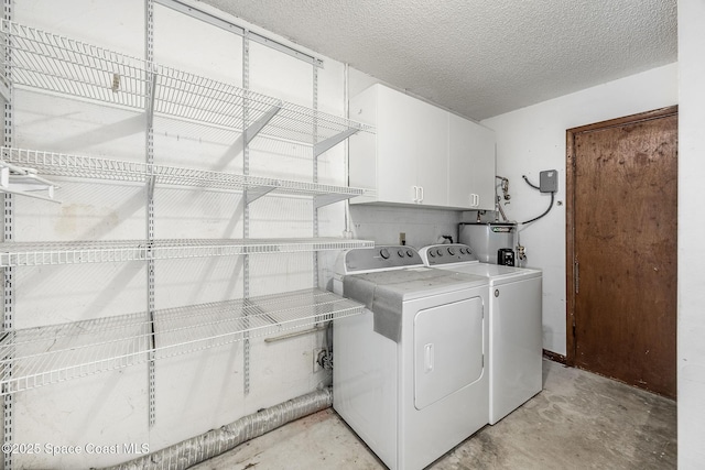 clothes washing area with cabinets, washing machine and dryer, water heater, and a textured ceiling