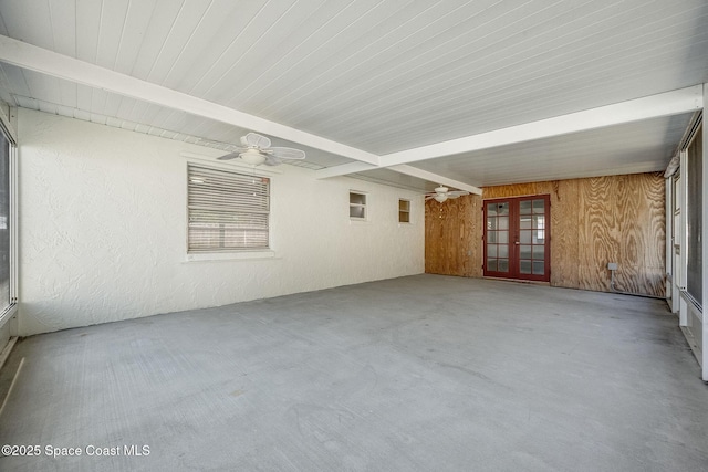 unfurnished sunroom with beam ceiling, ceiling fan, and french doors