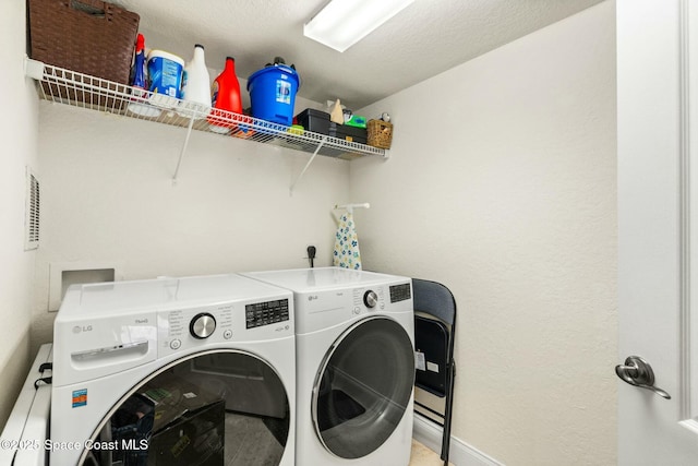 laundry room featuring washing machine and dryer and a textured ceiling