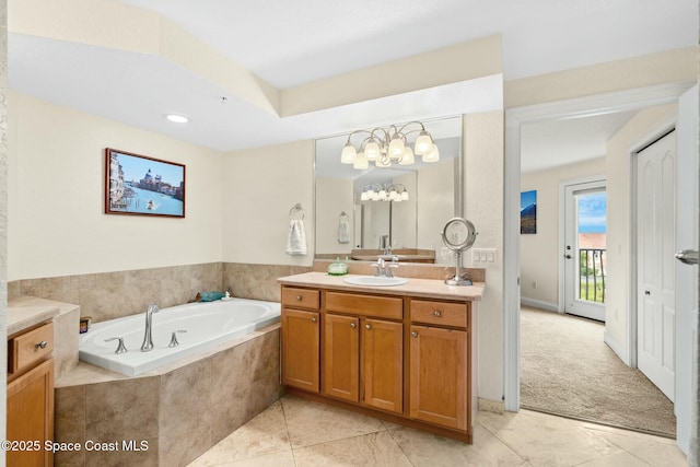 bathroom featuring a relaxing tiled tub, tile patterned floors, and vanity