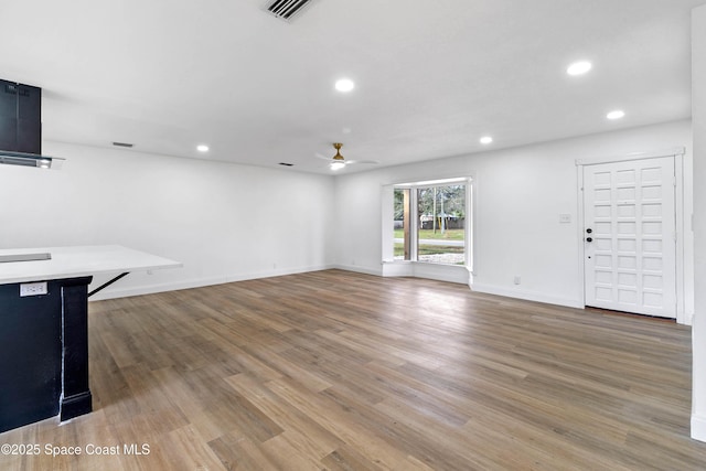 unfurnished living room featuring hardwood / wood-style flooring and ceiling fan