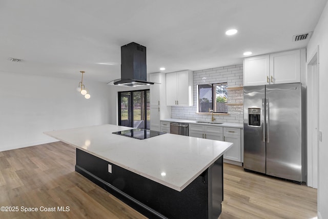 kitchen with white cabinets, stainless steel appliances, decorative backsplash, sink, and island range hood