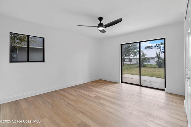 spare room featuring ceiling fan, light wood-type flooring, and a wealth of natural light