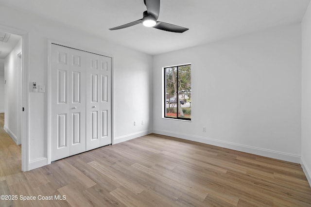 unfurnished bedroom with ceiling fan, a closet, and light hardwood / wood-style floors