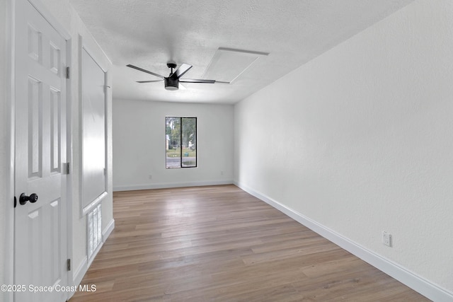 spare room featuring ceiling fan, a textured ceiling, and light hardwood / wood-style flooring