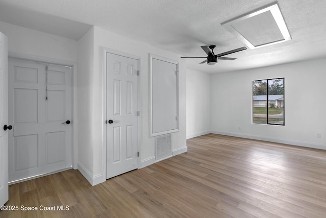 unfurnished bedroom featuring ceiling fan, a textured ceiling, and light hardwood / wood-style flooring