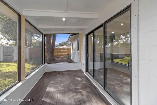 unfurnished sunroom featuring beamed ceiling