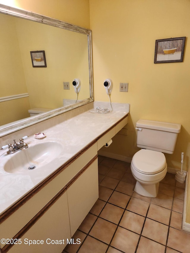 bathroom featuring toilet, tile patterned flooring, and vanity