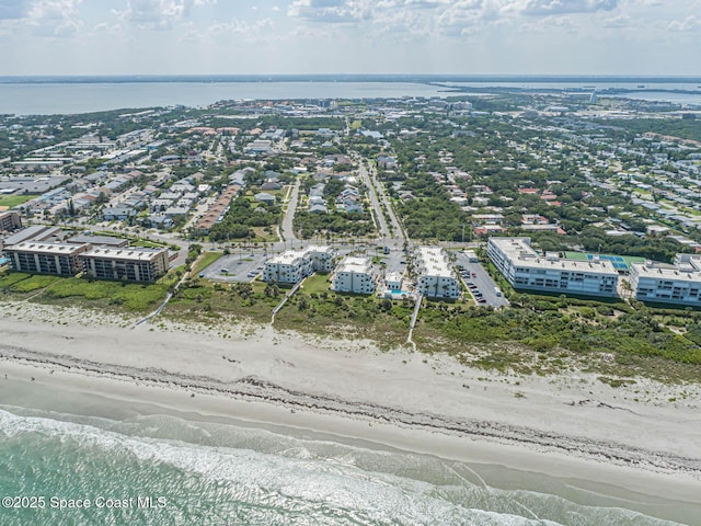 birds eye view of property with a water view and a beach view