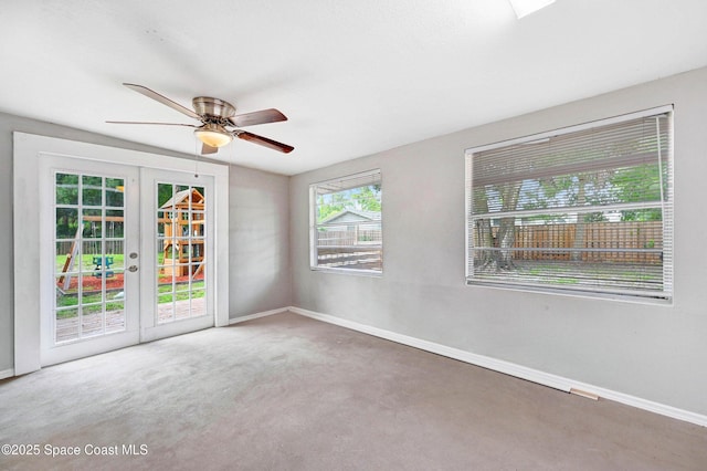 carpeted empty room with ceiling fan and french doors