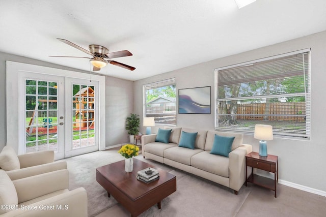 living room featuring ceiling fan, light colored carpet, and french doors