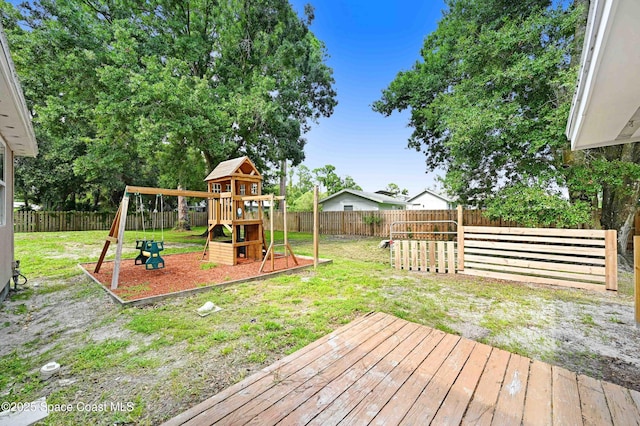 exterior space featuring a playground and a wooden deck