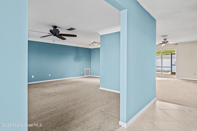 carpeted empty room featuring ceiling fan, crown molding, and a textured ceiling