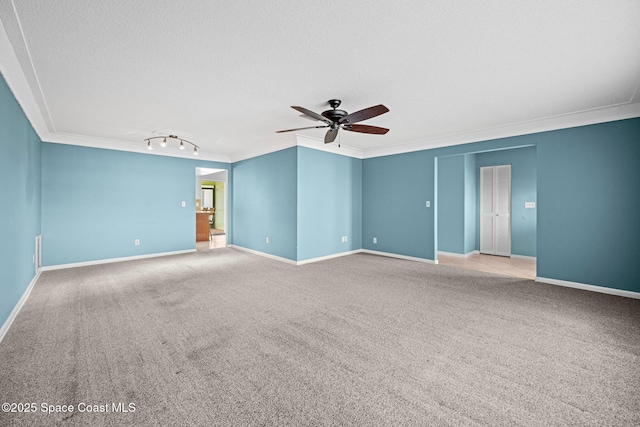 carpeted empty room featuring ceiling fan, a textured ceiling, and ornamental molding