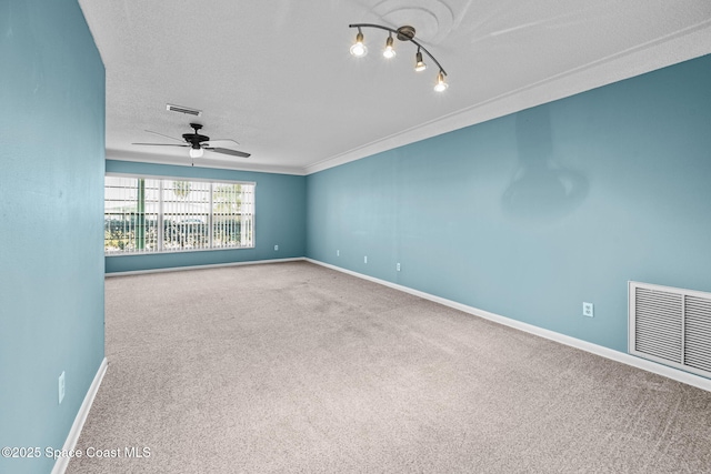 carpeted spare room featuring ceiling fan, a textured ceiling, and crown molding