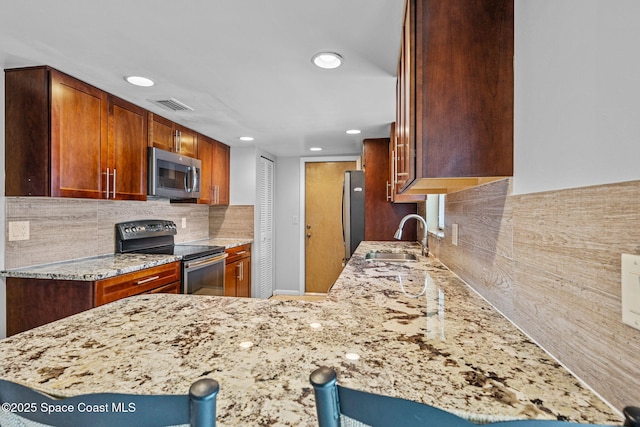 kitchen featuring a breakfast bar area, stainless steel appliances, kitchen peninsula, and sink