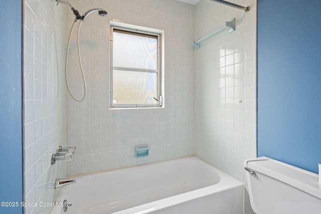 bathroom with toilet, a healthy amount of sunlight, and tiled shower / bath