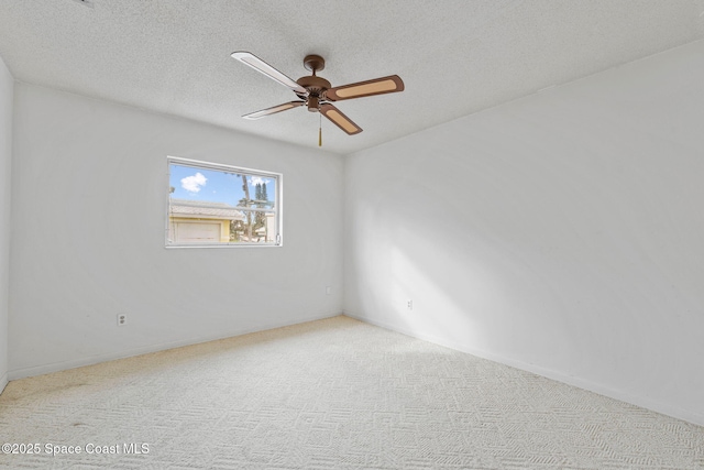 carpeted spare room featuring ceiling fan and a textured ceiling