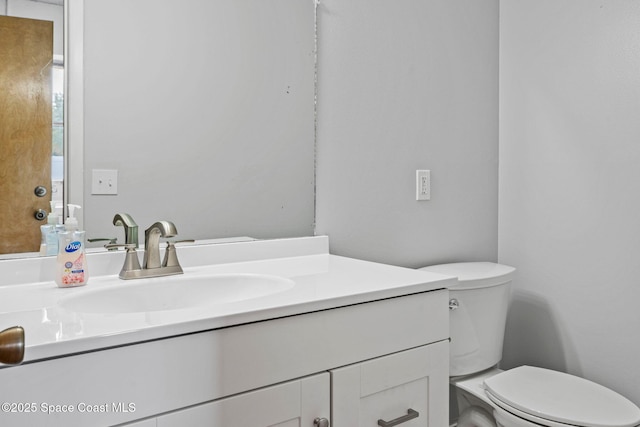 bathroom featuring toilet and vanity