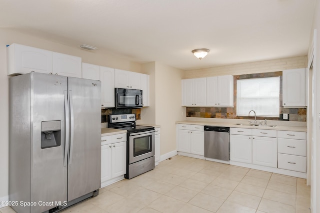 kitchen with backsplash, appliances with stainless steel finishes, sink, and white cabinetry