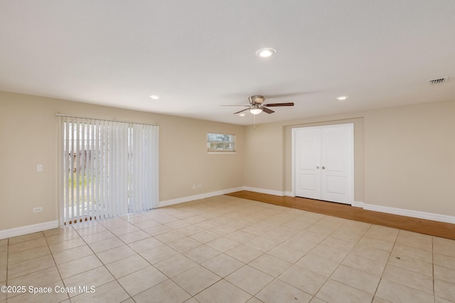 tiled empty room featuring ceiling fan