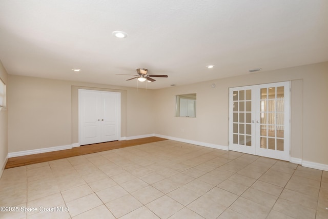 tiled spare room featuring ceiling fan and french doors