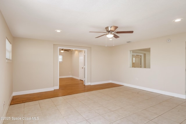 empty room with ceiling fan and light tile patterned floors