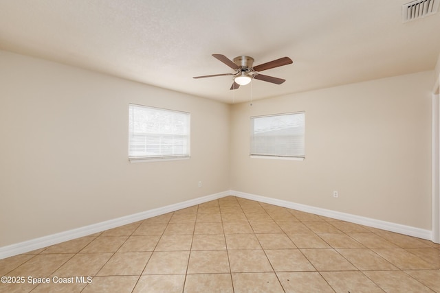 tiled empty room featuring ceiling fan