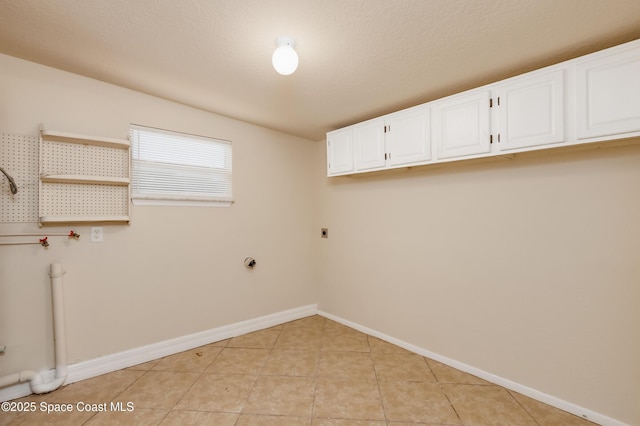 laundry area featuring cabinets, light tile patterned floors, and hookup for an electric dryer