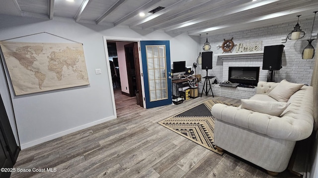 living room with a fireplace, beamed ceiling, and hardwood / wood-style floors