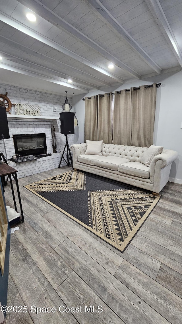 living room featuring beam ceiling, a brick fireplace, and wooden ceiling