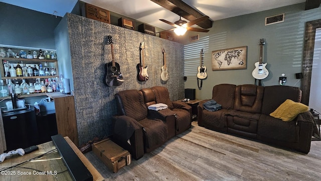 home theater with ceiling fan, beam ceiling, and hardwood / wood-style floors