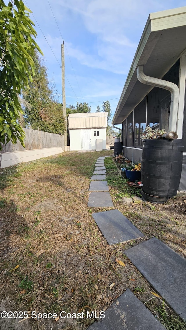 view of yard with a sunroom and a storage shed