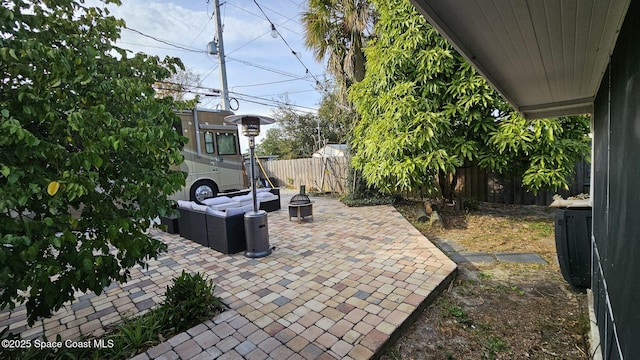 view of patio with an outdoor living space with a fire pit