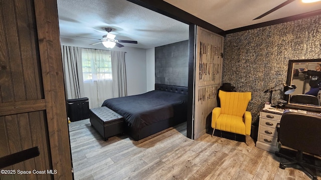 bedroom featuring ceiling fan, a textured ceiling, and light hardwood / wood-style flooring